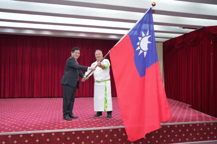 圖說二：外交部長林佳龍授旗給代表隊駱進漢總領隊並為代表隊加油打氣。