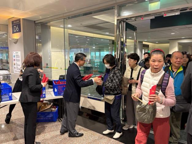 圖說一：外交部領事事務局桃園機場辦事處主任李盈興（左二）偕同仁代表政府於入境機門向平安返台國人表達慰問及關懷之意，並當場致贈內含蘋果酥之紅包，對國人平安回國表達祝福。