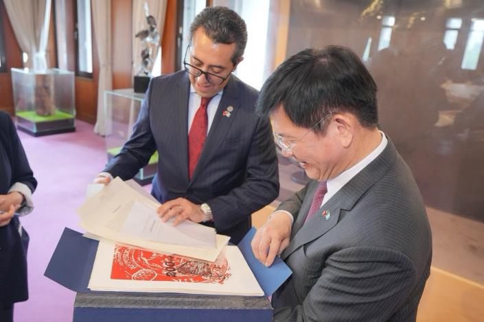 圖說二：瓜地馬拉共和國公共財政部長曼高斯（Jonathan Kiril Thomas Menkos Zeissig，左）致贈外交部長林佳龍（右）瓜地馬拉財政部成立200週年紀念郵票及版畫作品集。