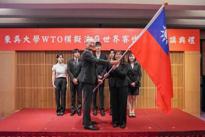 圖說一：外交部政務次長吳志中授旗予代表隊秦懿楦同學並為代表隊加油打氣。