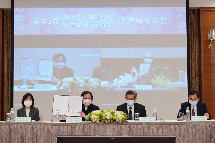 圖說二：臺灣日本關係協會會長邱義仁（左二）與日本台灣交流協會會長大橋光夫（後方螢幕右），展示簽署備忘錄。