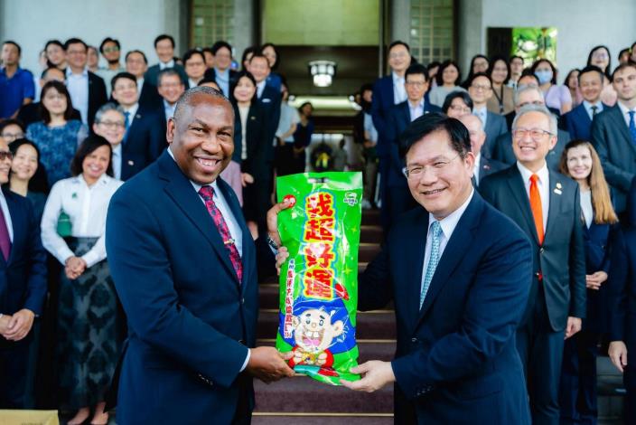 2. Saint Lucian Ambassador Robert Kennedy Lewis, Dean of the Diplomatic Corps, accepts from Minister Lin a bag of well-known local snacks printed with an auspicious message on behalf of the ambassadors and representatives in attendance.
